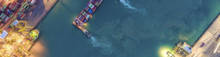 Container ship carrying ocean freight anchored in port | Seacon Logistics