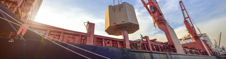 Crane lifts heavy metal onto container ship | Seacon Logistics